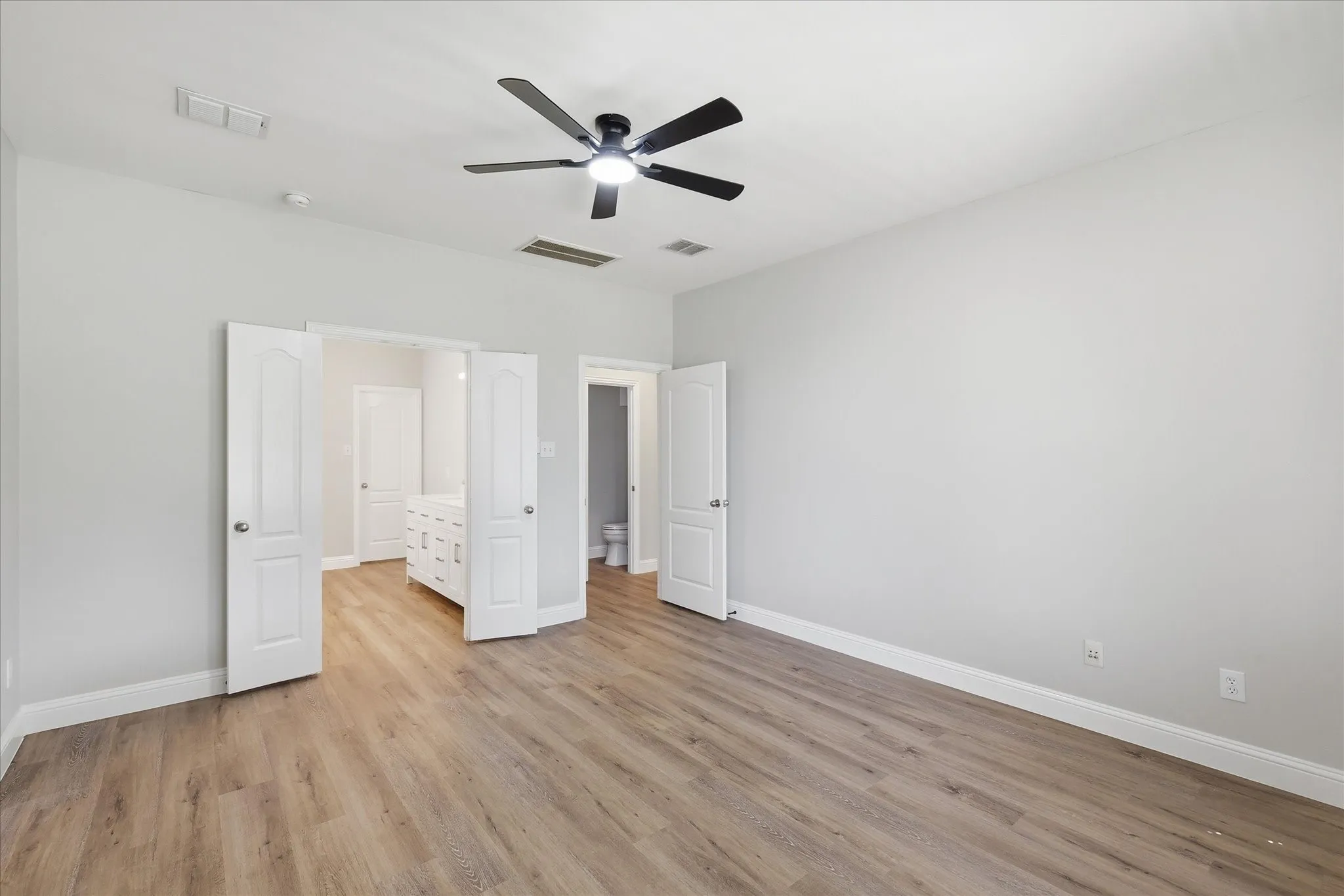 Double doors lead from the primary suite to the ensuite bath.
