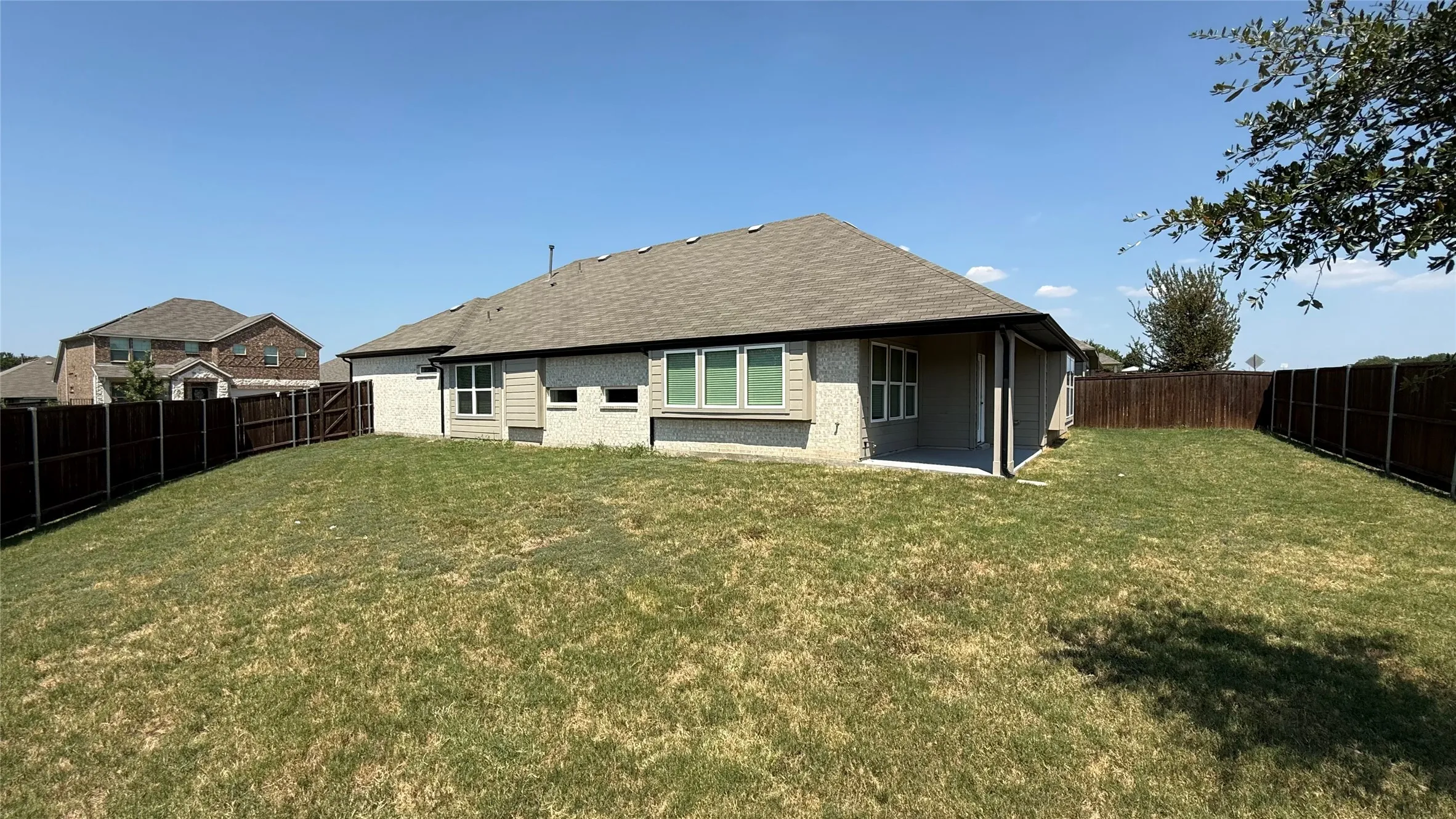 Spacious single-story residence with a composite shingle roof and multi-pane windows, set on a generous lot with a manicured lawn
