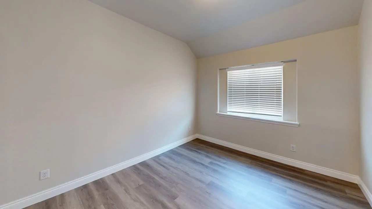 Recessed window with blinds, wood-finish flooring, and light-toned walls