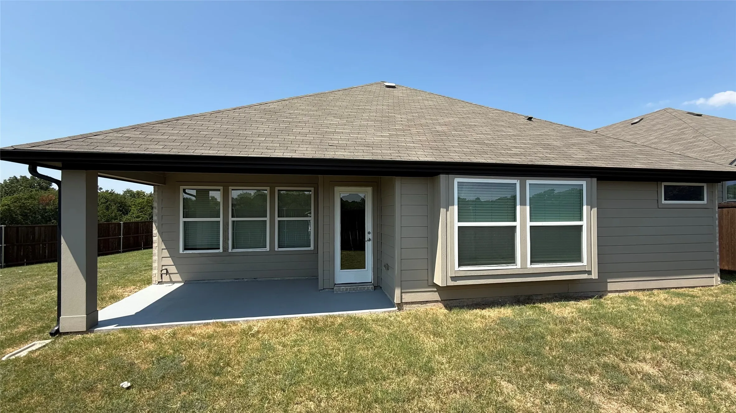 Covered patio with a concrete surface, multiple large windows, and horizontal siding
