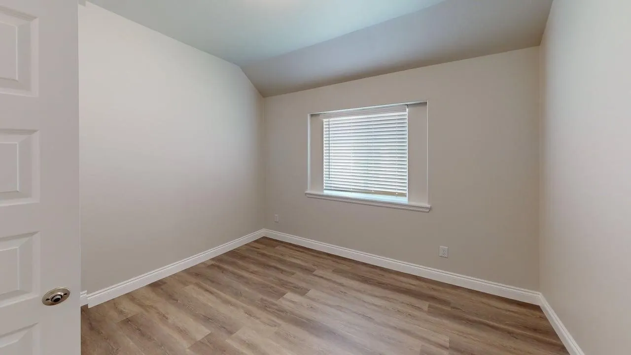 Wood-finish flooring throughout, neutral wall tones, and a window with blinds