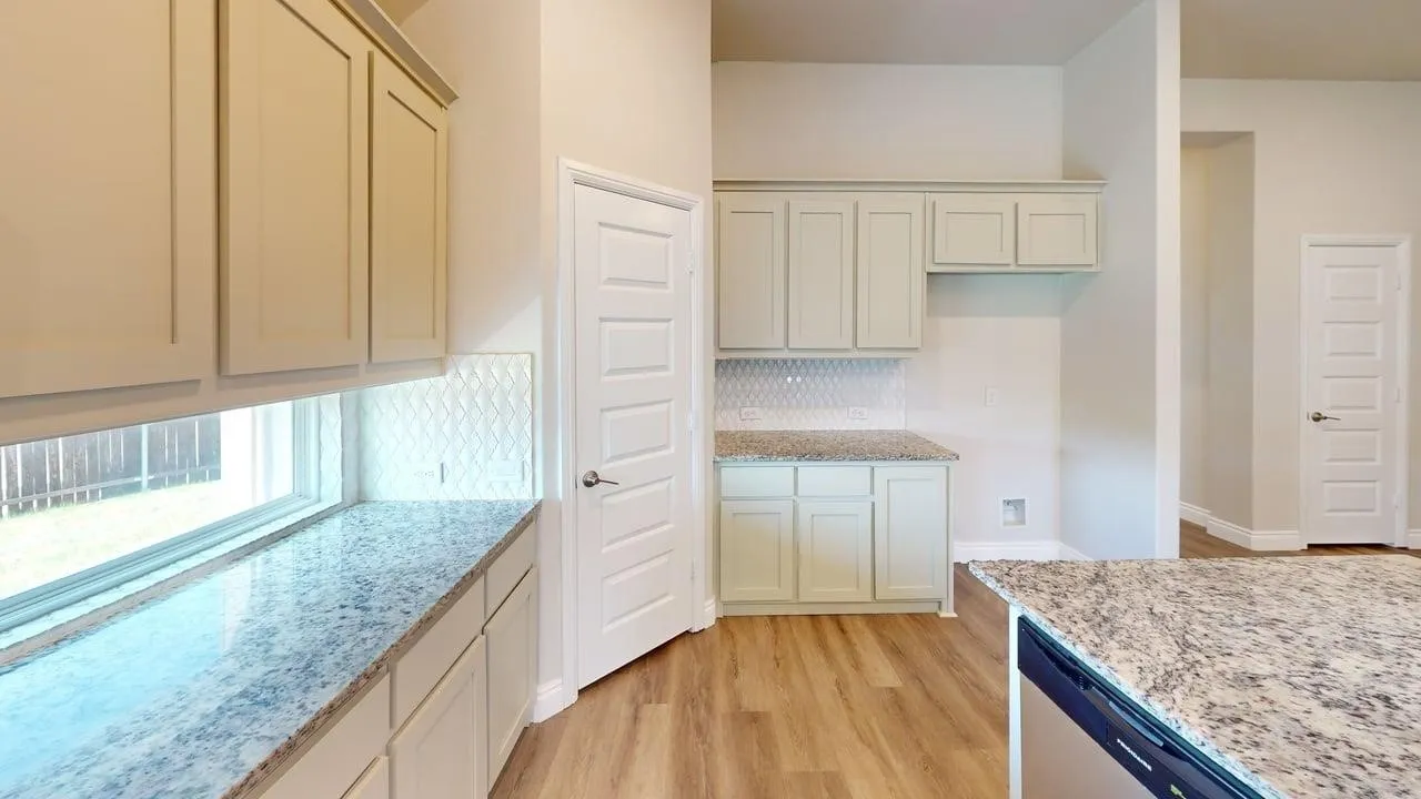 Kitchen featuring light cabinetry, granite countertops, wood-finish flooring, and a subway tile backsplash