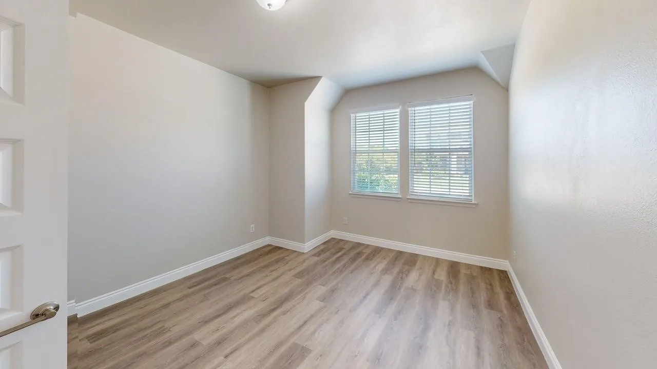Wood-finish flooring, white trim, and neutral wall tones