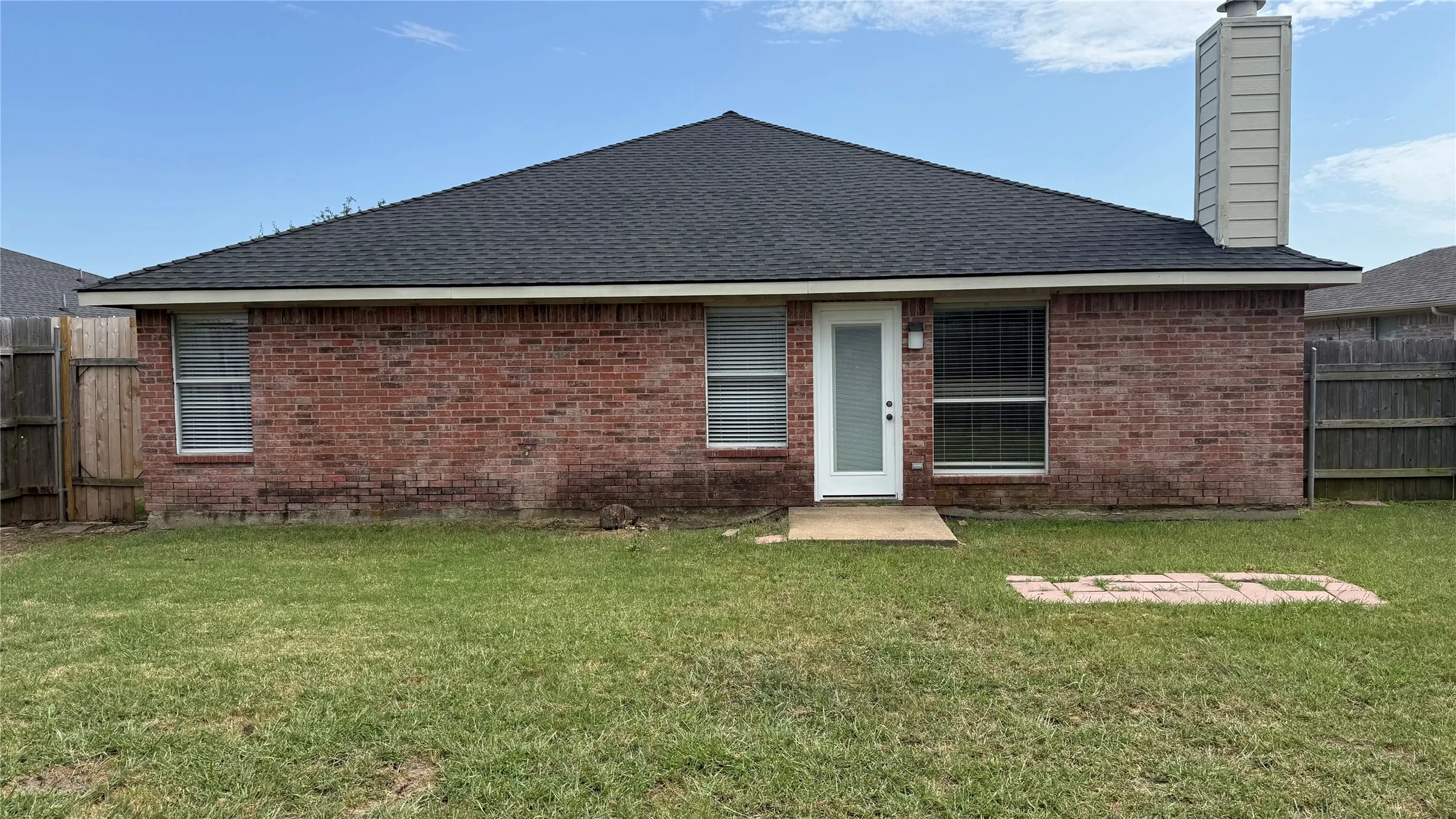 Charming brick ranch home featuring a gabled roof, front entry with sidelights, and multiple windows providing natural light