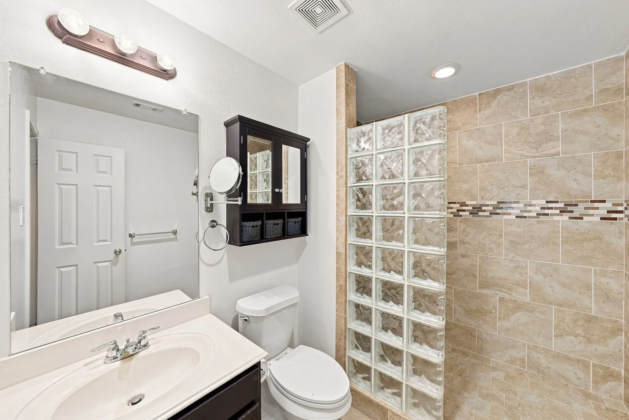 Tile-surround shower with a glass block partition and decorative accent band