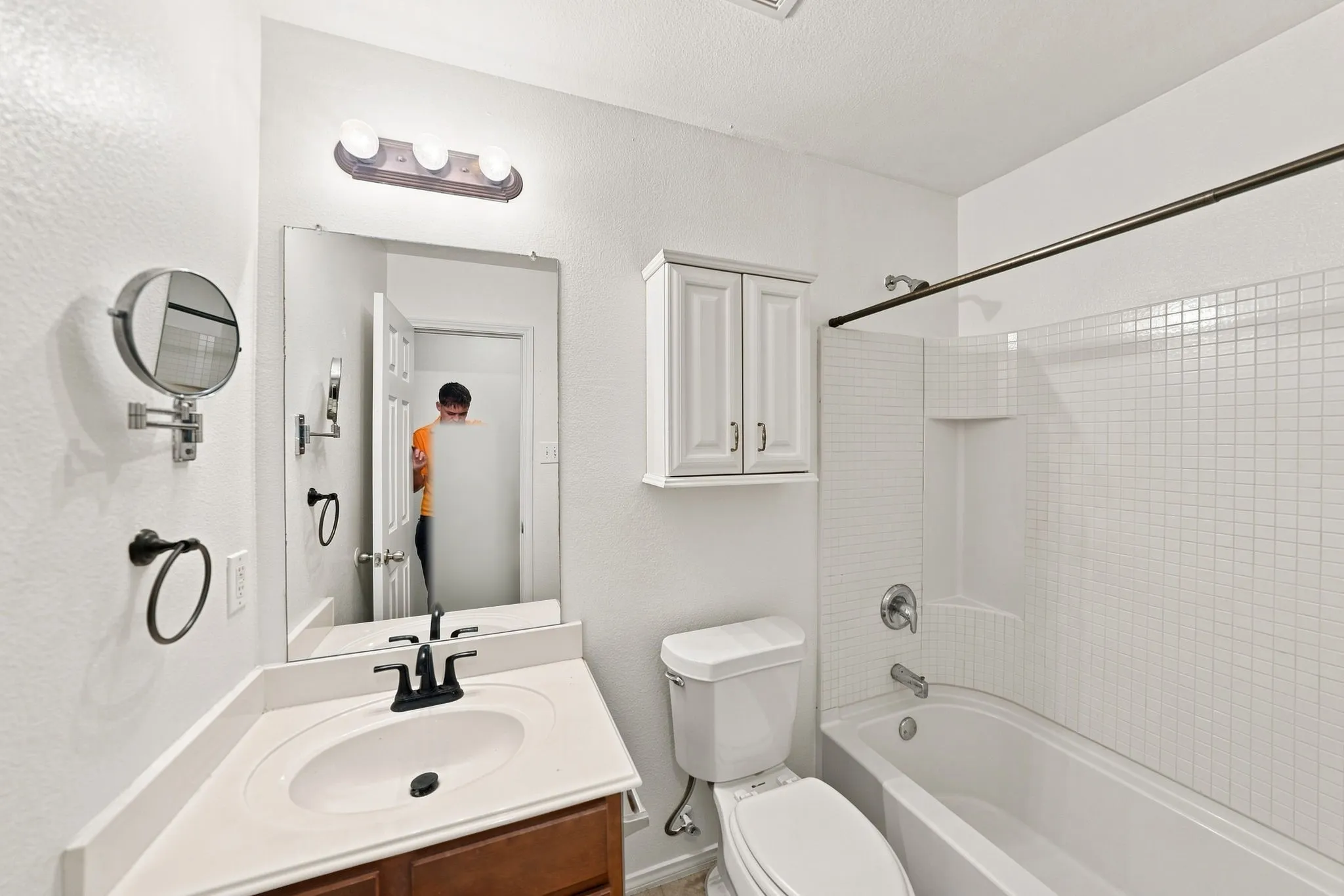 Bathroom featuring a single vanity with dark wood-finish cabinetry, white countertop, and black fixtures