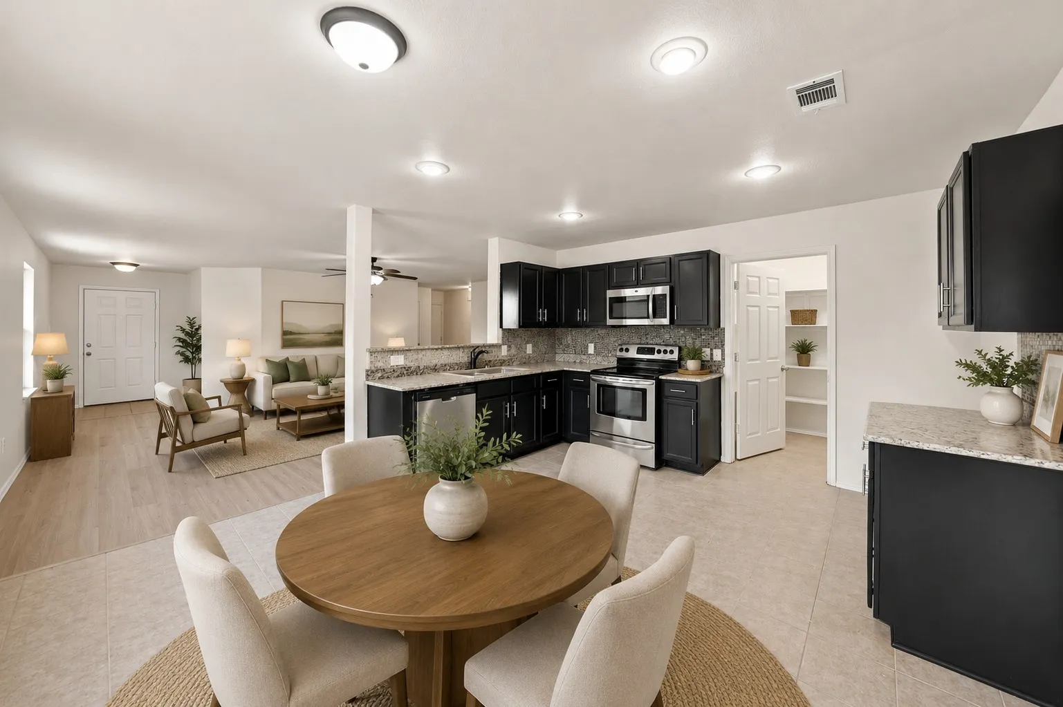 Virtually Staged -Kitchen featuring black cabinetry, stainless steel appliances, and light-toned countertops