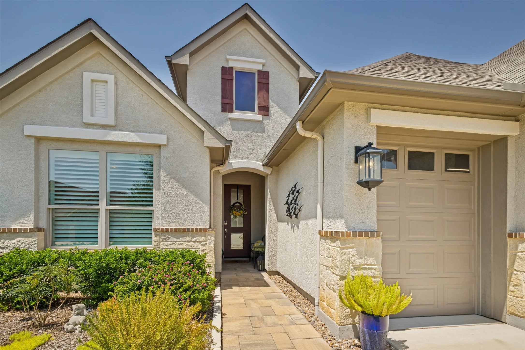 PAVESTONE WALKWAY, DIVIDED LIGHT ENTRY DOOR, DESIGNER LANTERNS, ELEVATION W GOLF CART GARAGE.