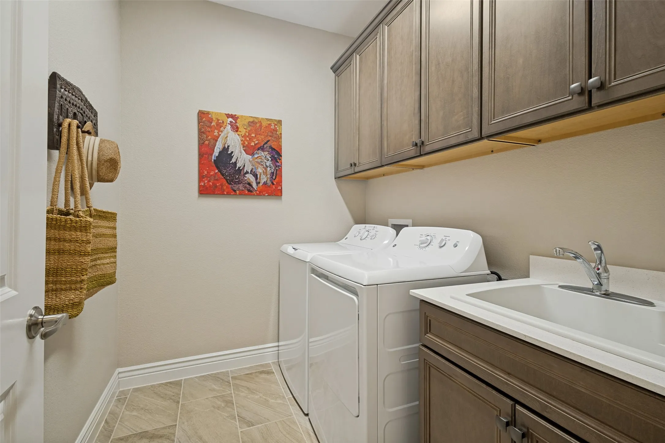 LAUNDRY ROOM IS COMPLETE WITH FULL SIZE WASHER AND DRYER, SINK AND UPPER AND LOWER CABINETS.