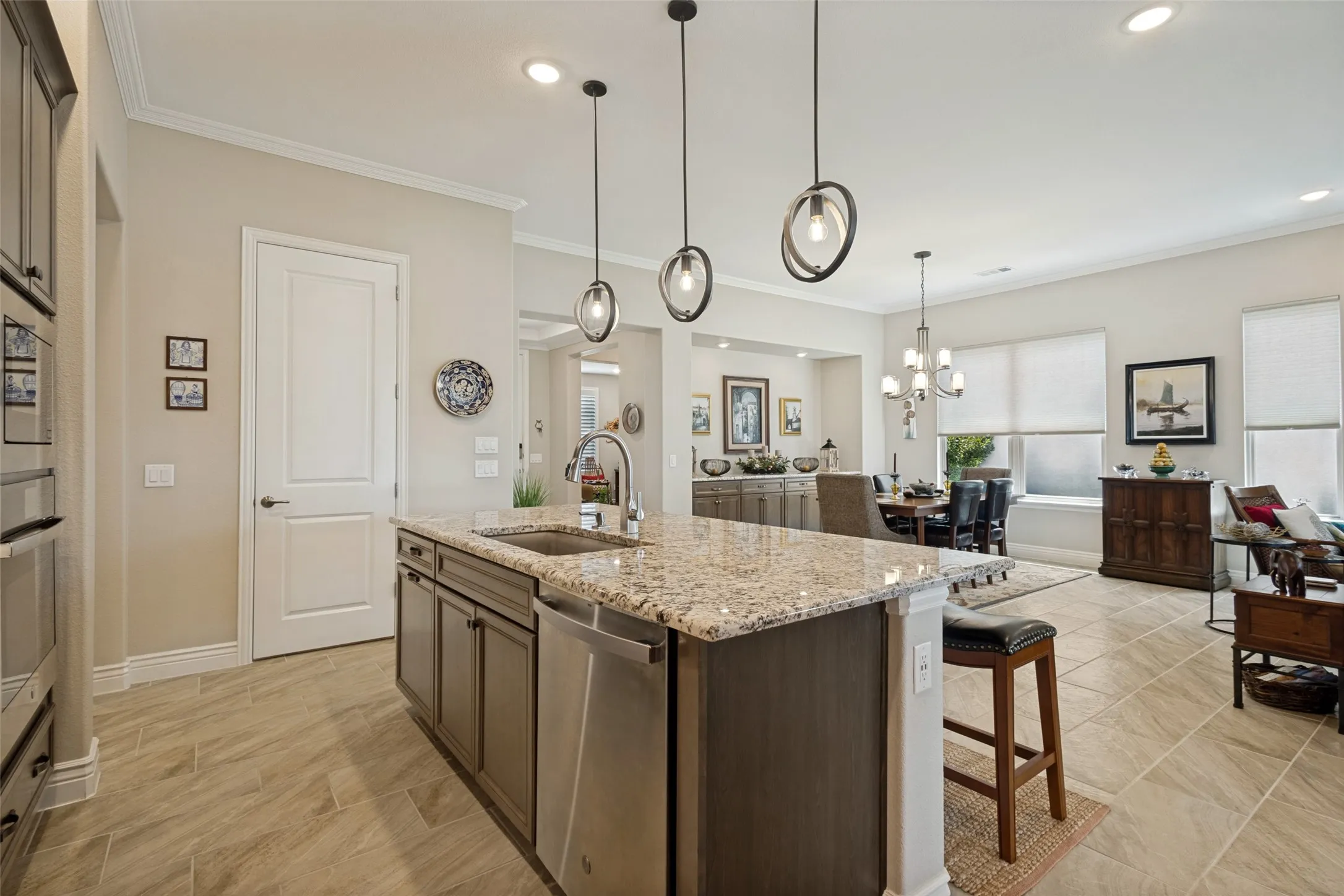 LOVE THE PENDANT LIGHTS THAT COMPLIMENT THE RICH NEUTRAL PALLET. GRANITE ISLAND, QUARTZ COUNTERS.
