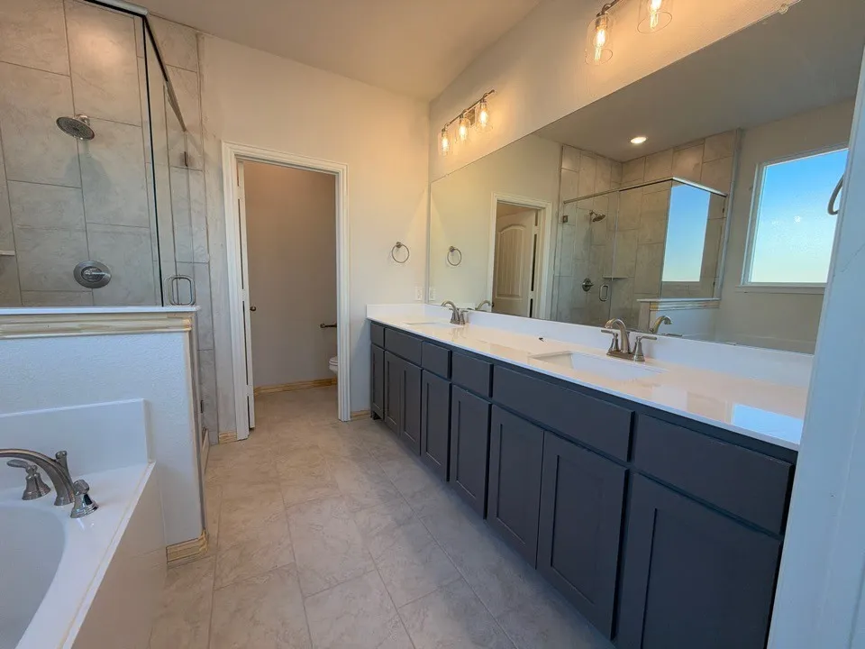 Dual vanity with white countertops, undermount sinks, and dark cabinetry
