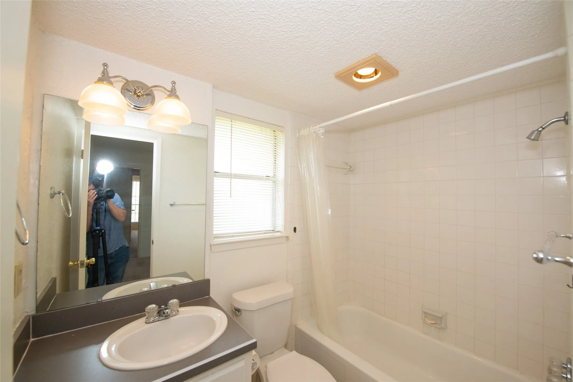 Bathroom featuring a full vanity with an integrated sink, polished chrome faucet, and a large mirror
