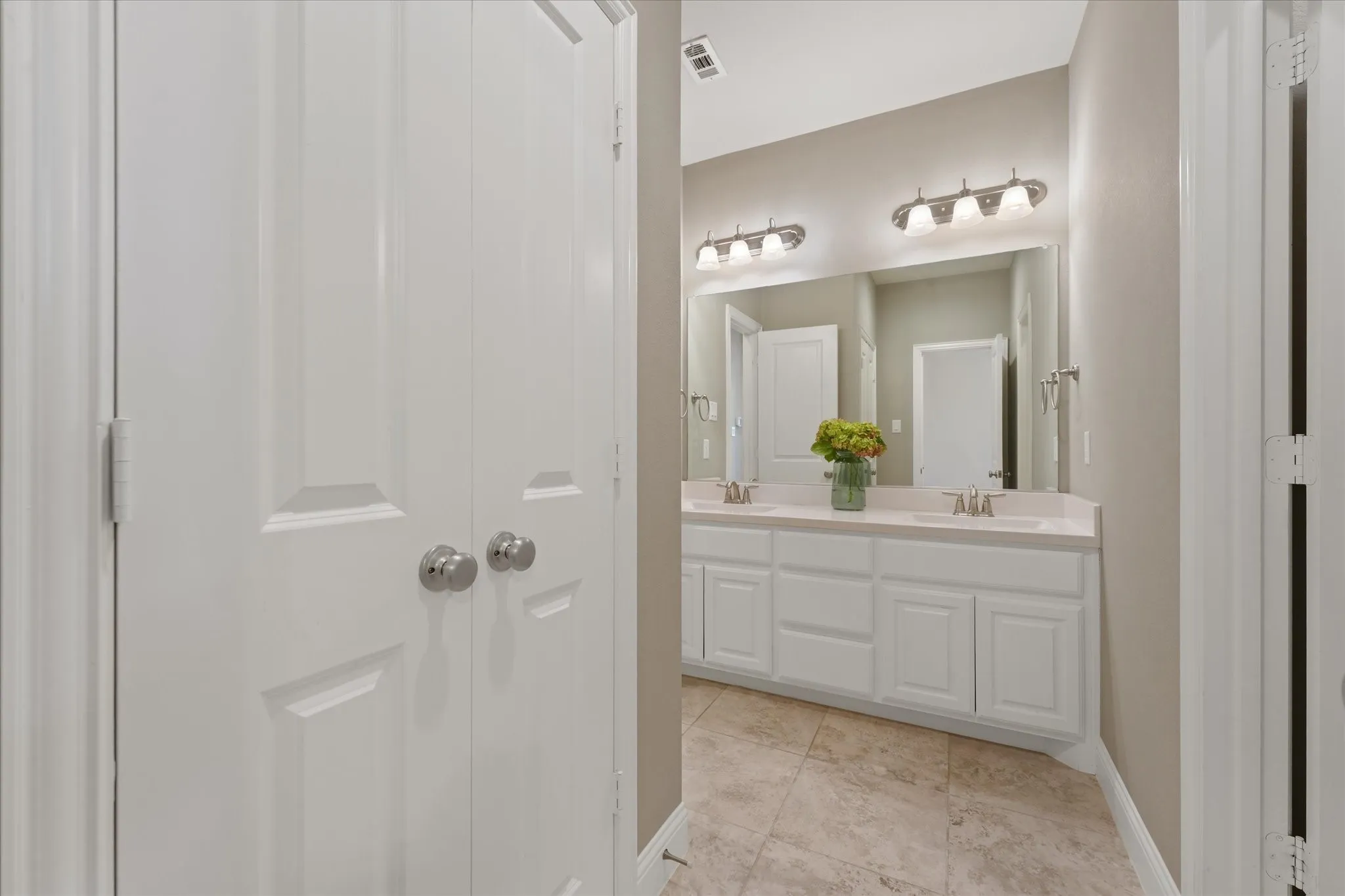Dual-sink vanity with generous counter space and storage, positioned between the home’s secondary bedrooms.