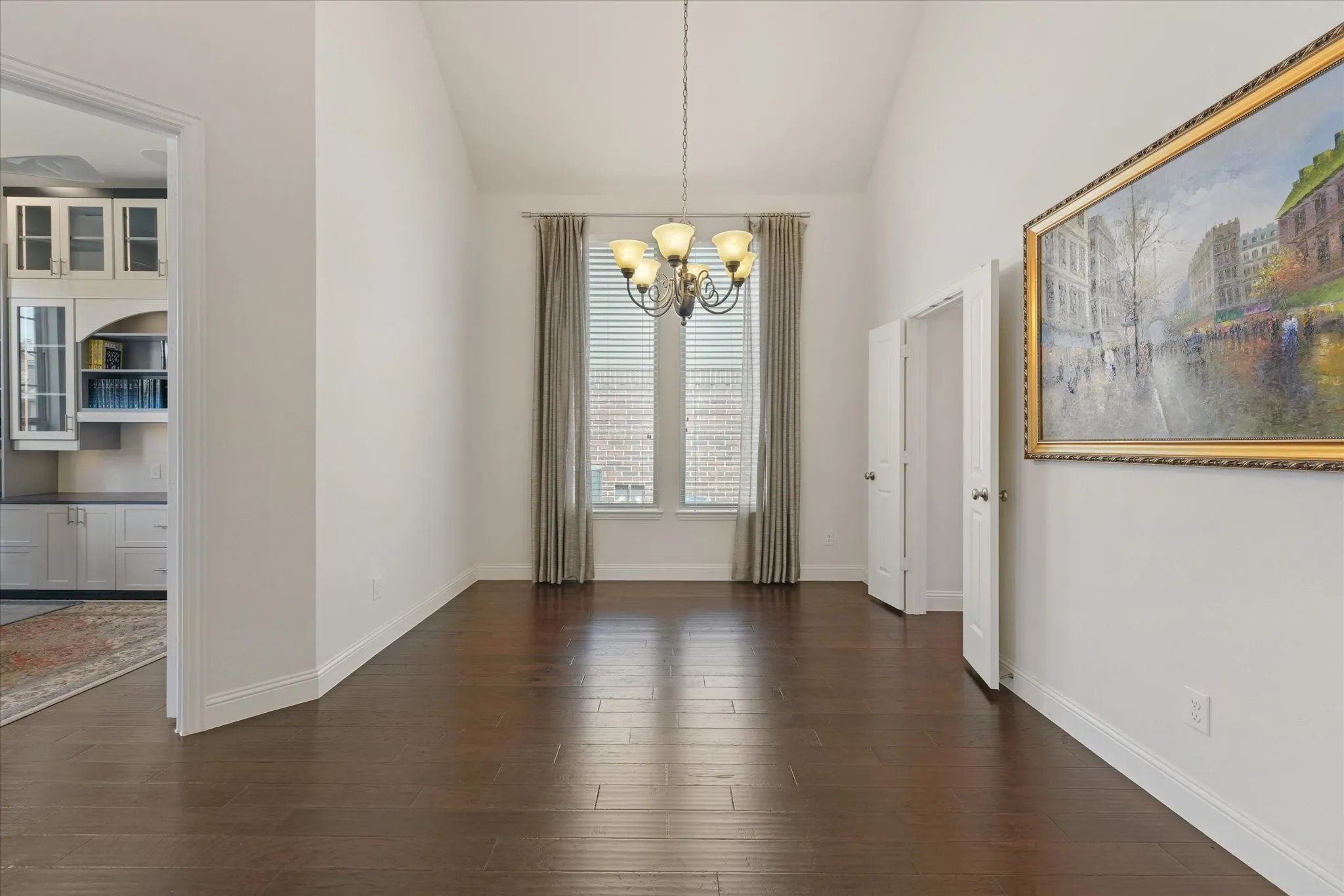 Dedicated dining room with tall ceilings, hardwood floors and space for a large table, located next to the study and main living areas.