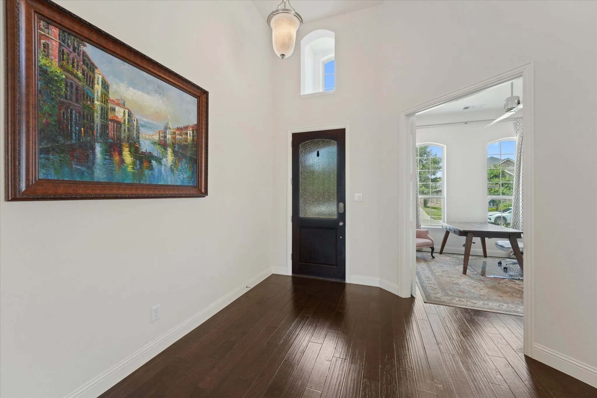 Bright entry with high ceilings, engineered hardwood flooring and direct access to the private home office near the front of the house.