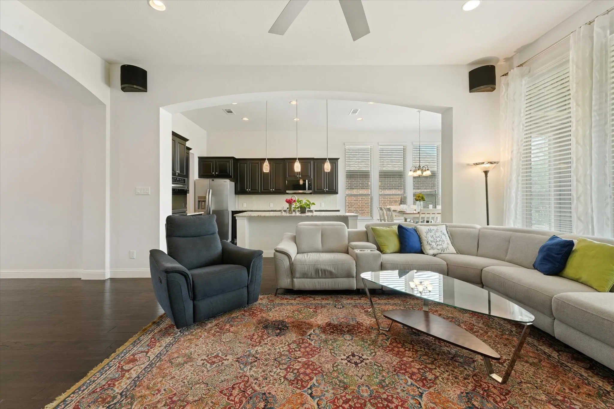 Open-concept living room and kitchen with engineered hardwood floors, high ceilings, large windows and flexible space for everyday living.