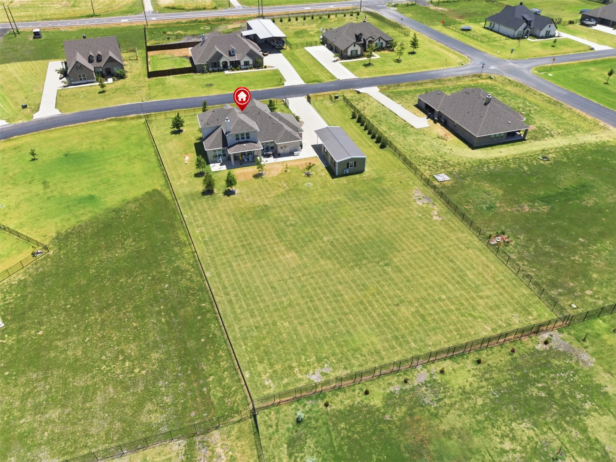 Expansive residential lot featuring a substantial manicured lawn with defined property lines, mature landscaping, and a multi-structure home situated on approximately one acre
