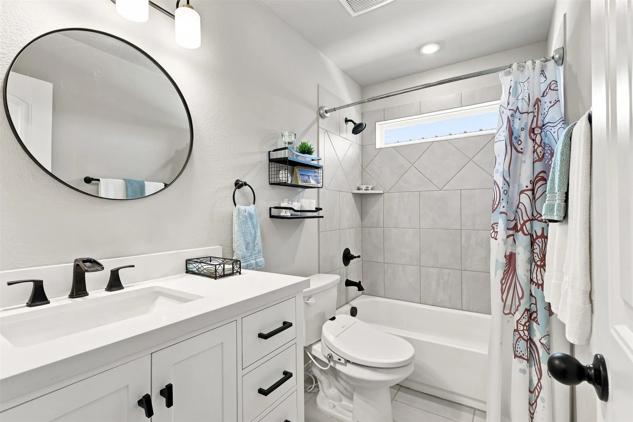 Spa-inspired bathroom featuring a clean-lined vanity with ample storage, quartz countertop, and matte black hardware