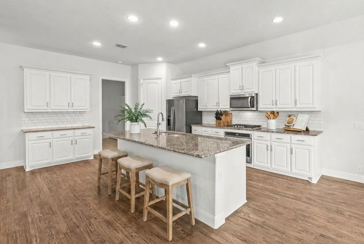 Handsome hand scrapped wood flooring. Crisp white cabinets, large island and lots of storage!