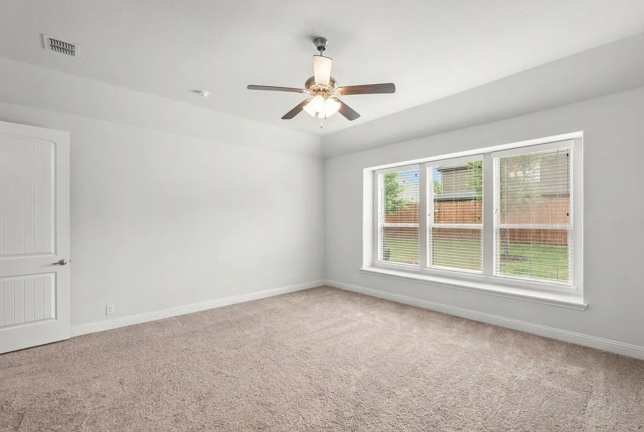 Primary bedroom privately tucked toward the rear of the home, split from other two bedrooms. Views overlooking the peaceful backyard.