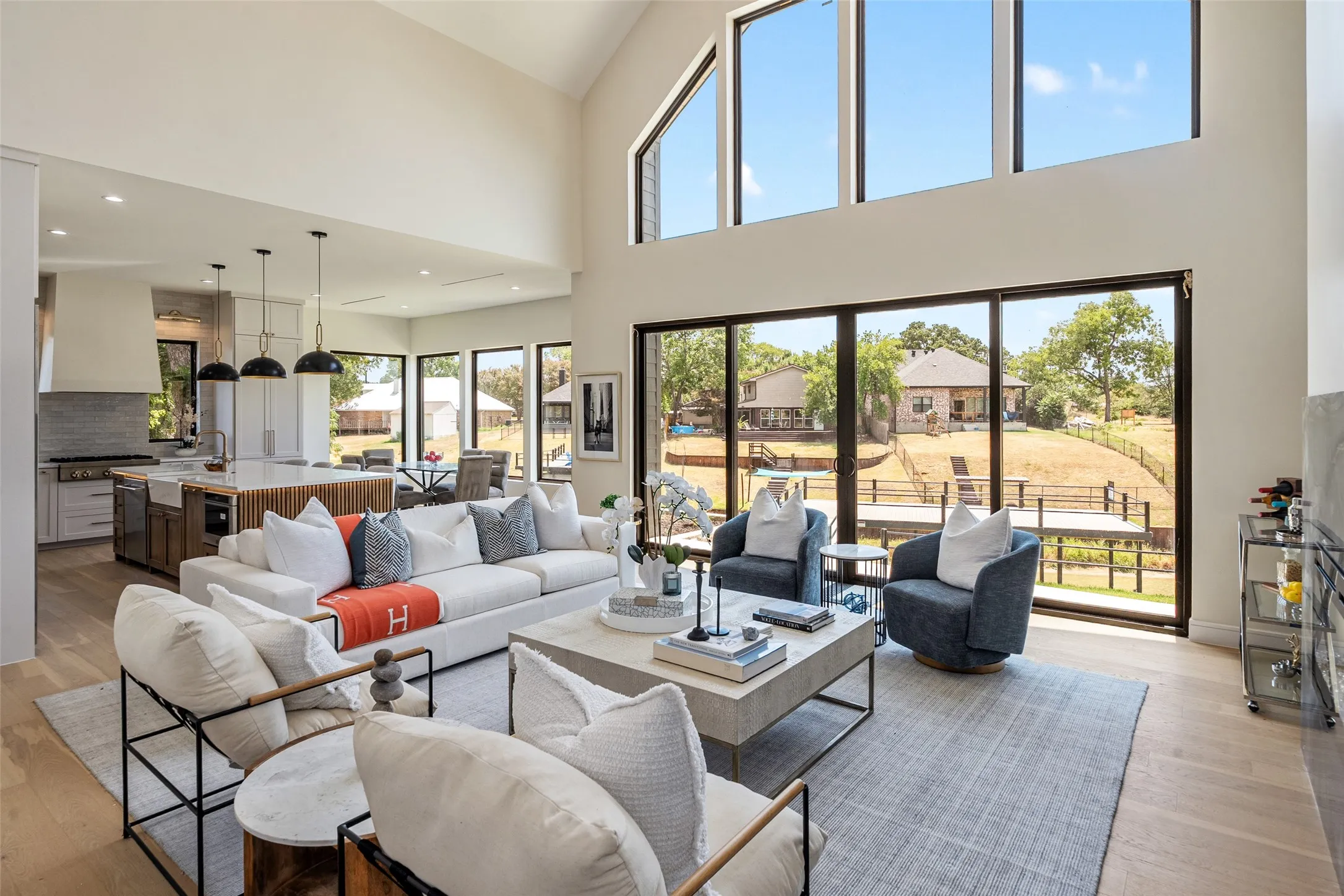 Soaring vaulted ceilings, expansive floor-to-ceiling windows, wood-finish flooring, and an open-concept layout