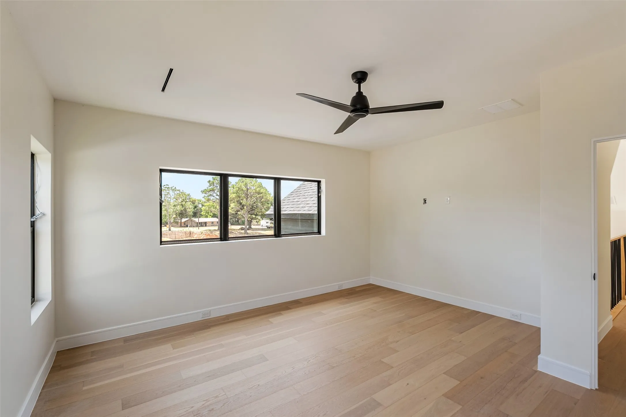 Wood-finish flooring, white walls, and a contemporary ceiling fan