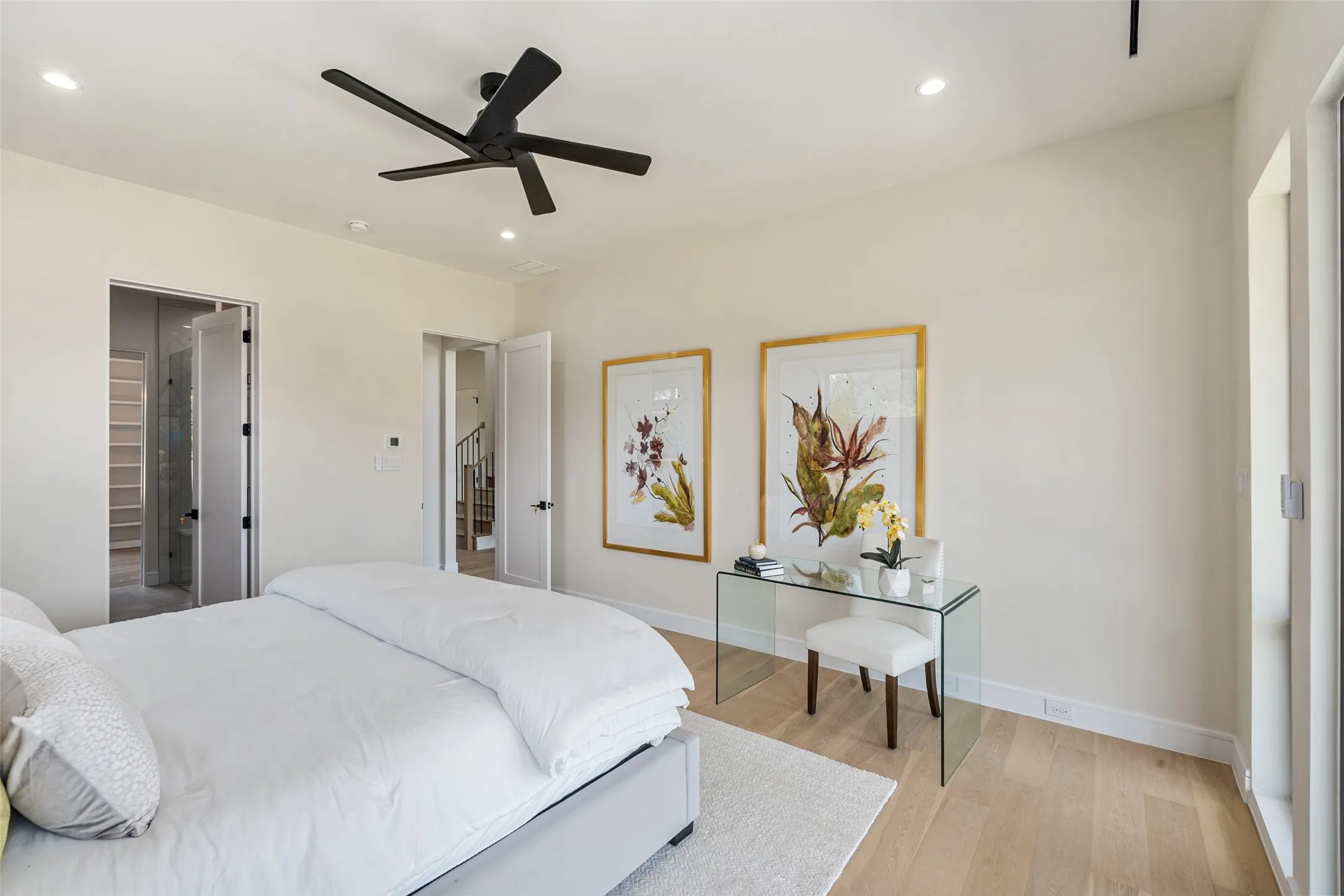 Light wood-finish flooring, recessed lighting, and a modern black ceiling fan