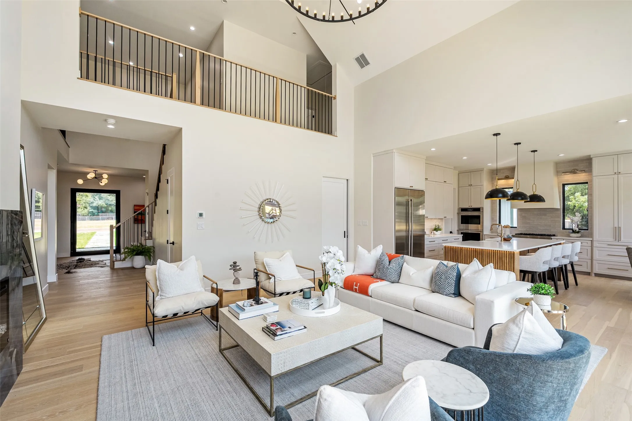 Double-height ceiling, wood-finish flooring, open-concept kitchen, custom cabinetry, kitchen island with seating