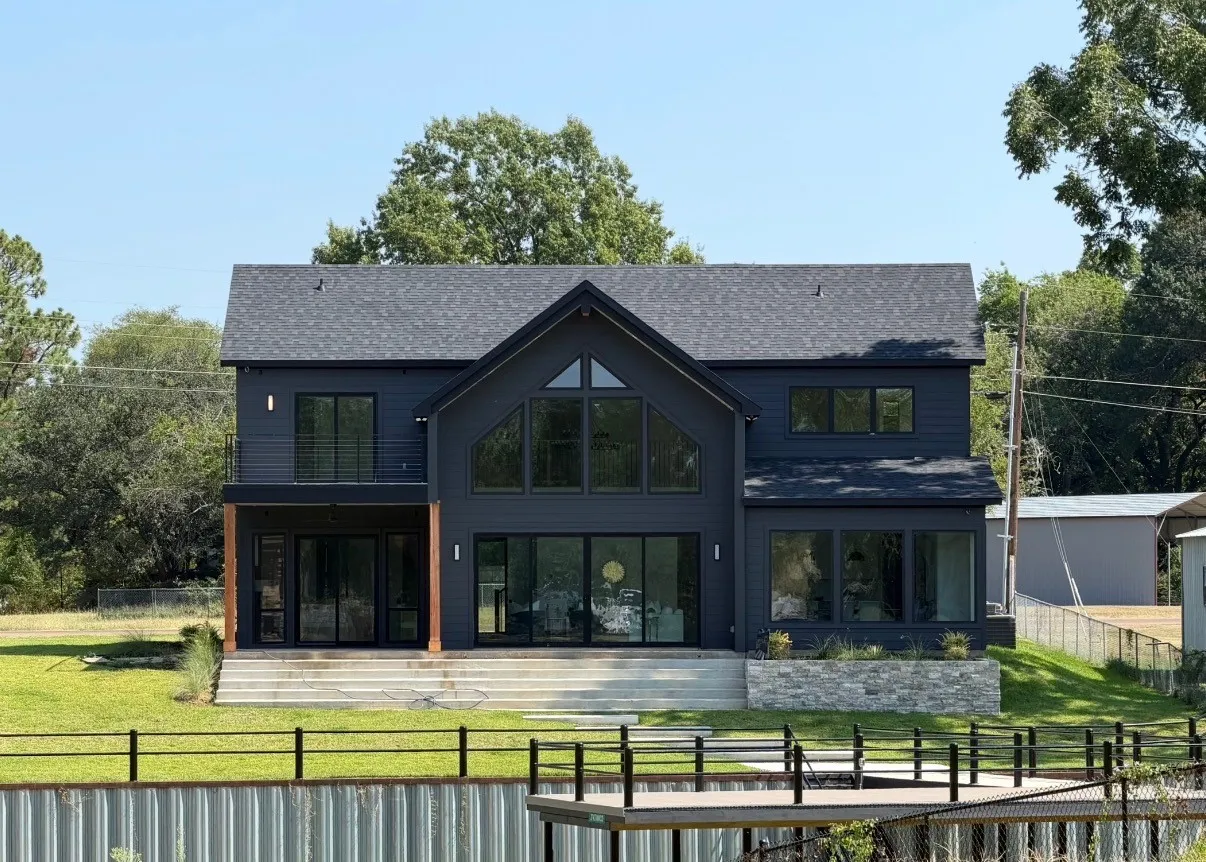 Modern two-story residence with a dark exterior and gabled roof
