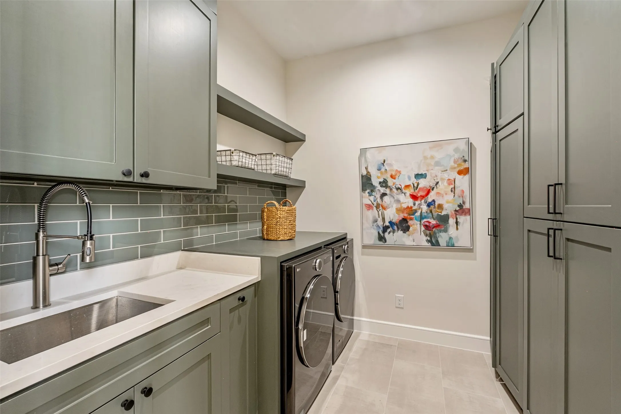 Laundry area featuring extensive built-in cabinetry, integrated sink, and an undermount countertop