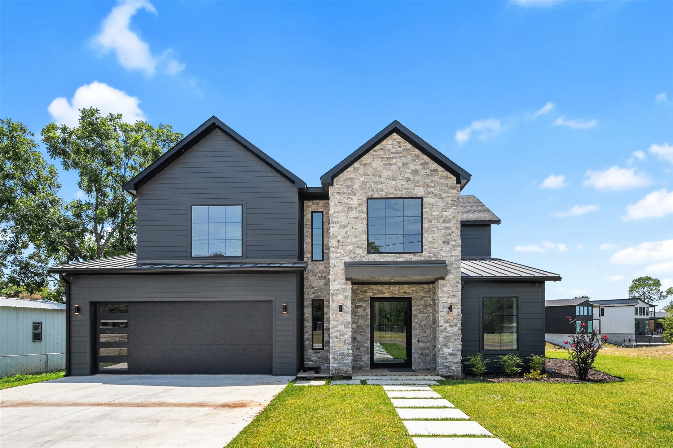 Modern exterior with a stone facade and dark horizontal siding