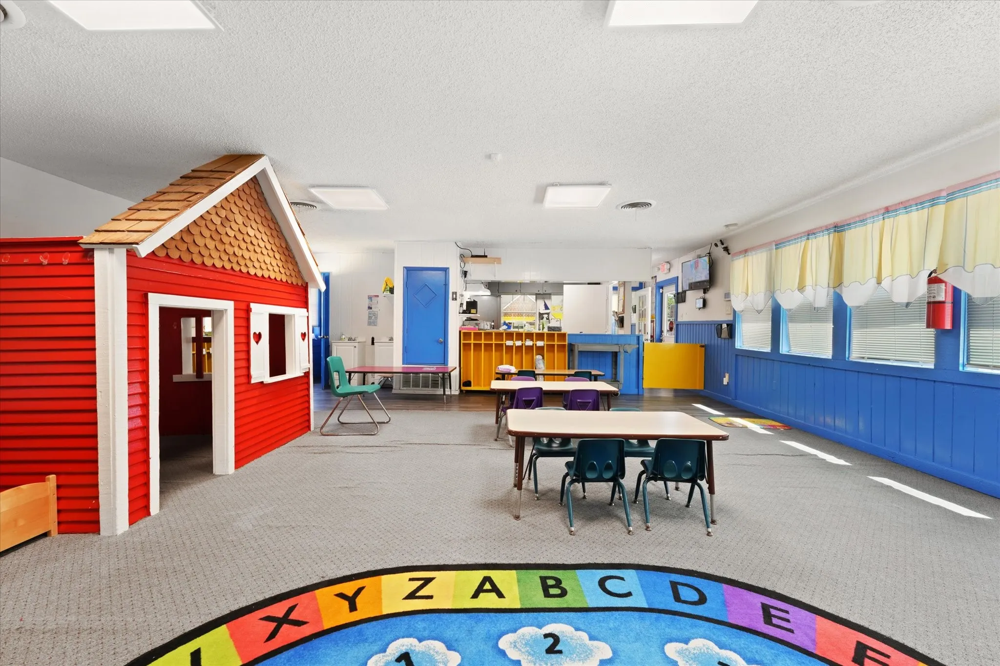 Spacious learning environment featuring bright natural lighting from multiple skylights and windows, durable polished concrete flooring, and flexible open layout