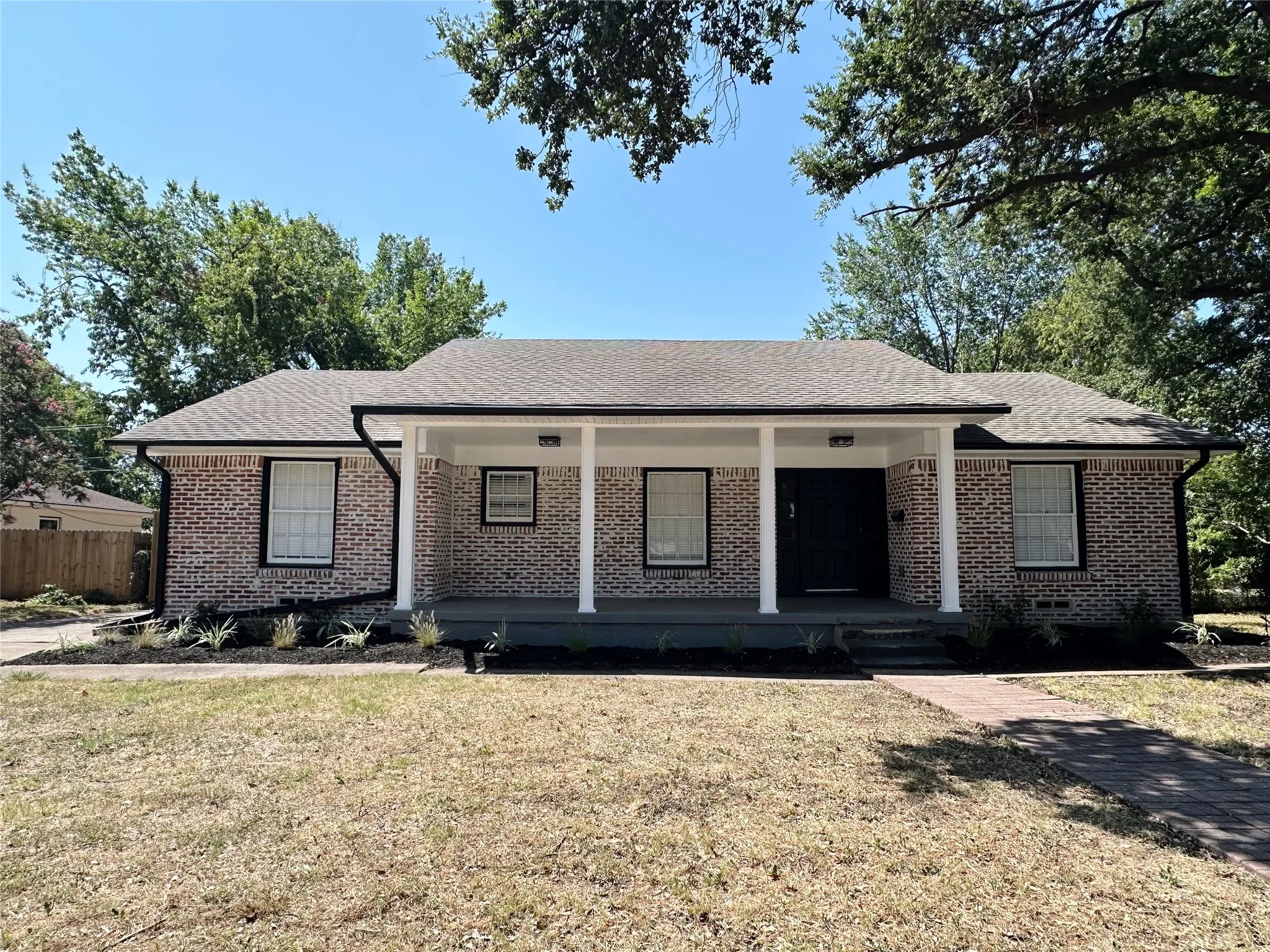Brick exterior with a covered front porch featuring white columns