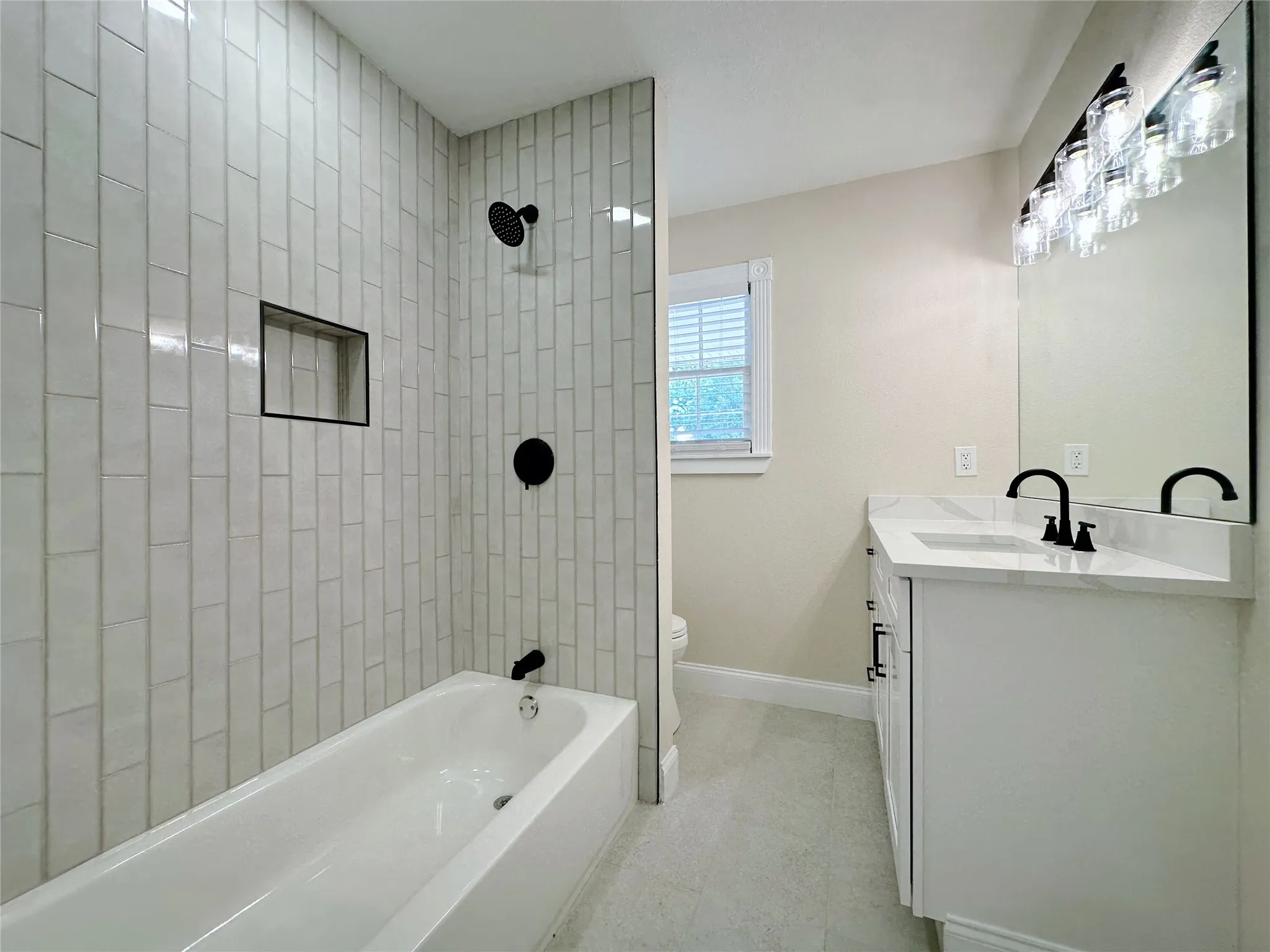 Bathtub with subway tile surround and integrated shower niche