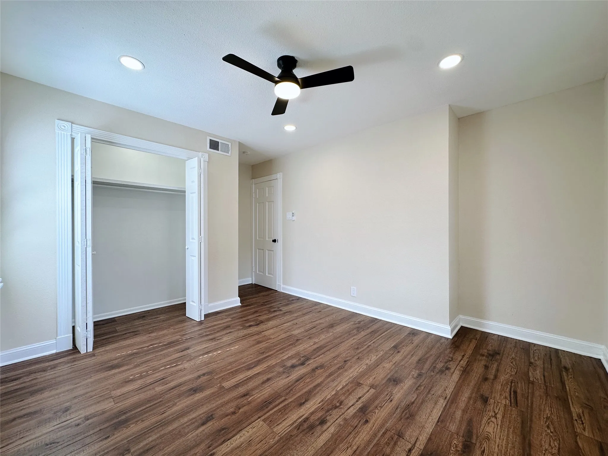 Wood-finish flooring, recessed lighting, ceiling fan with light, white trim, and a bi-fold closet