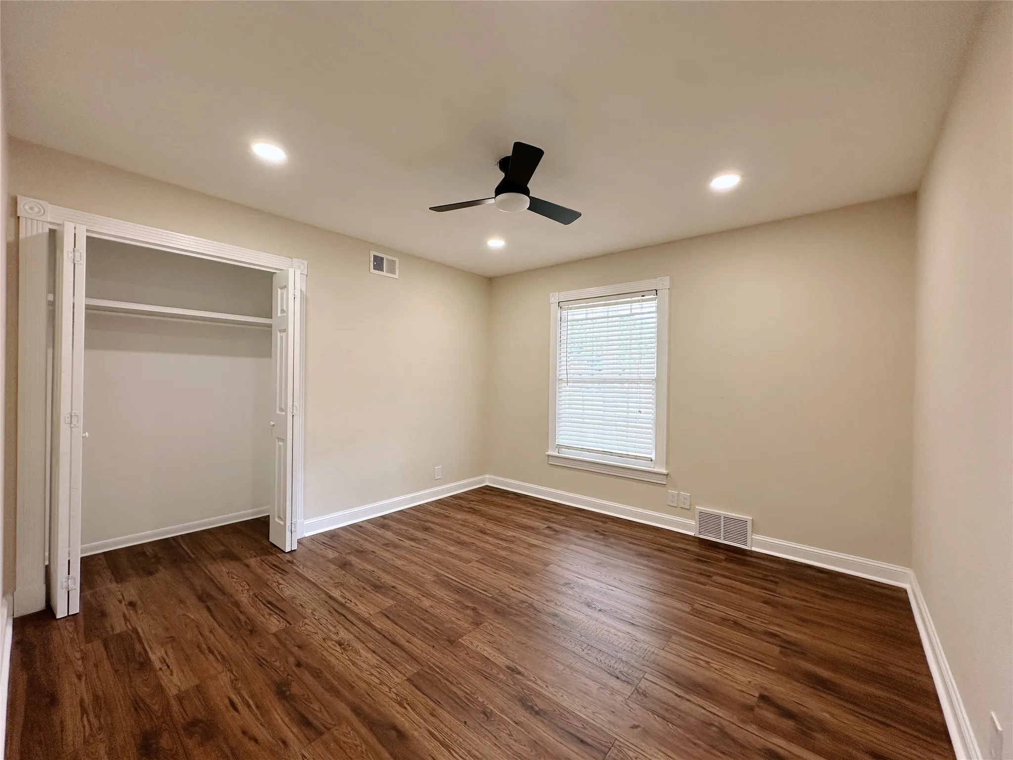 Recessed lighting, wood-finish flooring, ceiling fan, bi-fold closet, and window with blinds