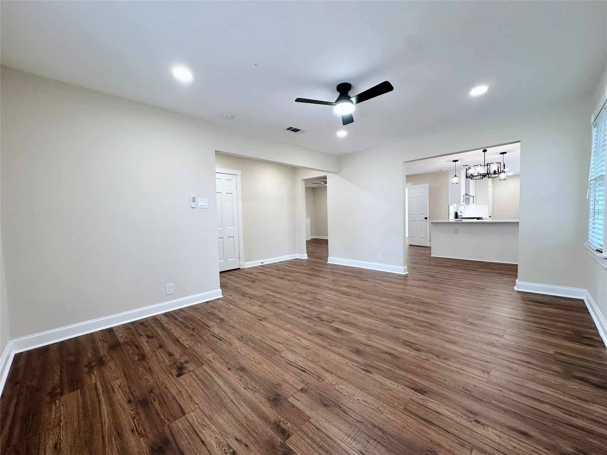Wood-finish flooring throughout, recessed ceiling lighting, a ceiling fan, and an open concept layout