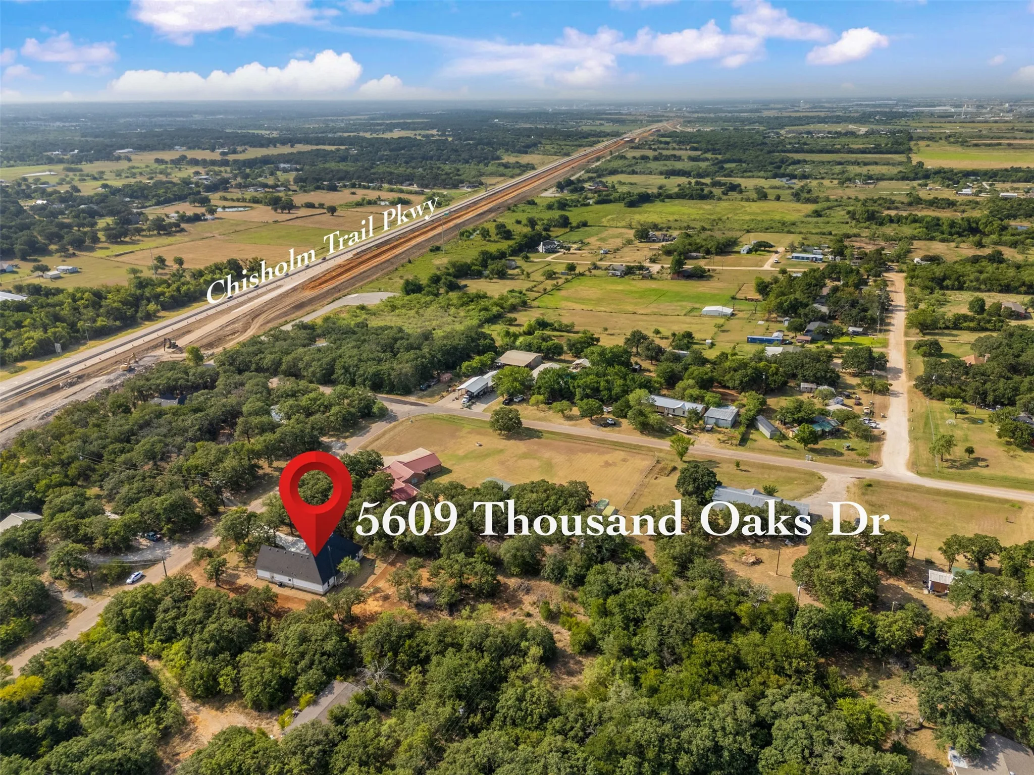 Scenic rural acreage at 5609 Thousand Oaks Dr featuring mature oak trees, open pastureland, and direct highway access via the nearby Churchill Trail Parkway