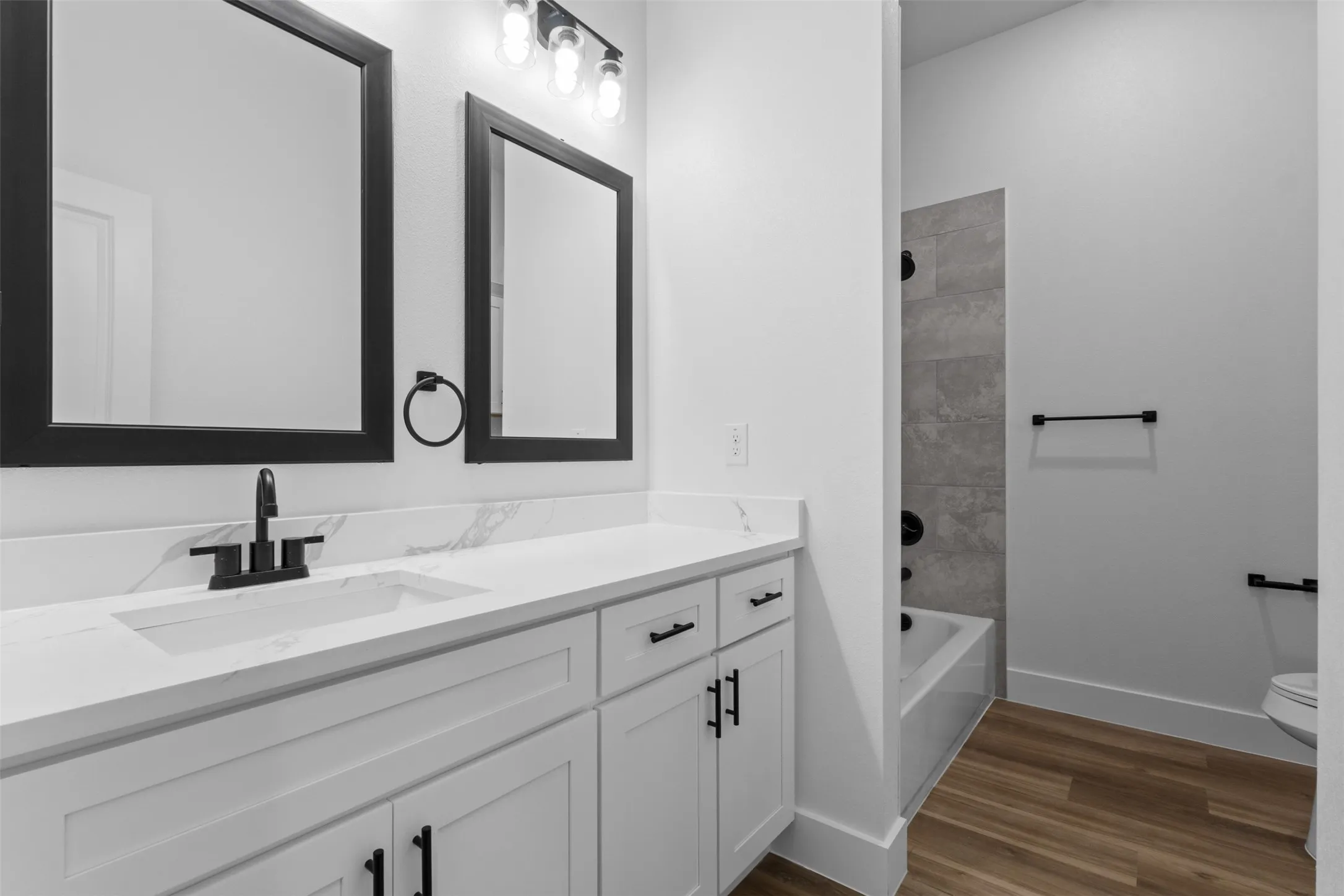 Dual vanity with white cabinetry and matte black hardware