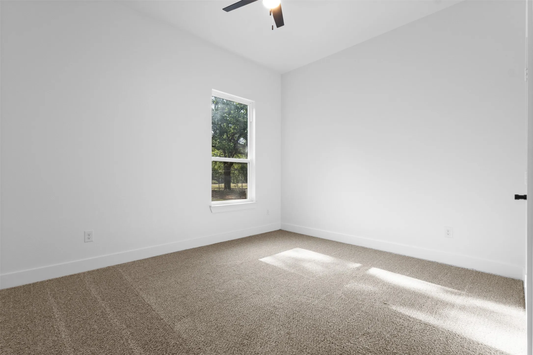 Vaulted ceiling with a ceiling fan, neutral carpet flooring, and a single window