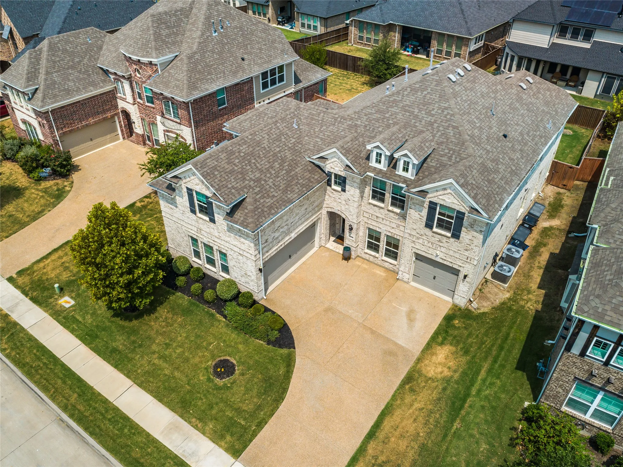 Stone and brick facade with multiple gables, a two-car garage, and a separate single-car garage