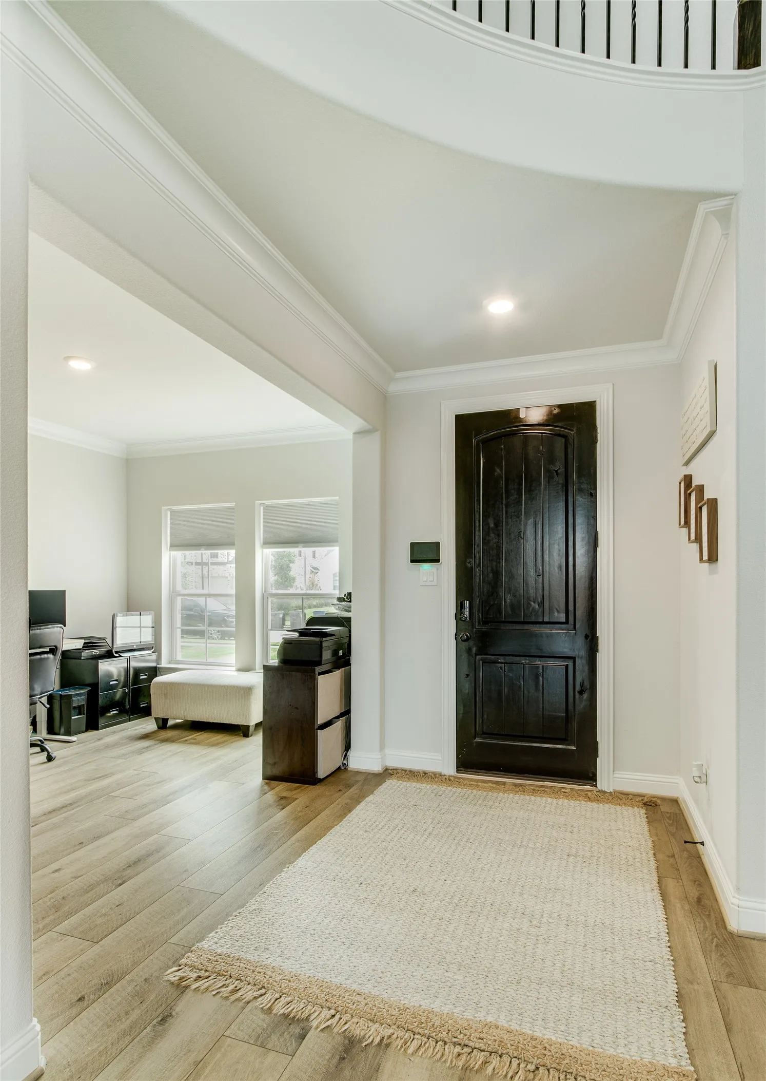 Entryway featuring a dark wood-paneled door, recessed lighting, and crown molding