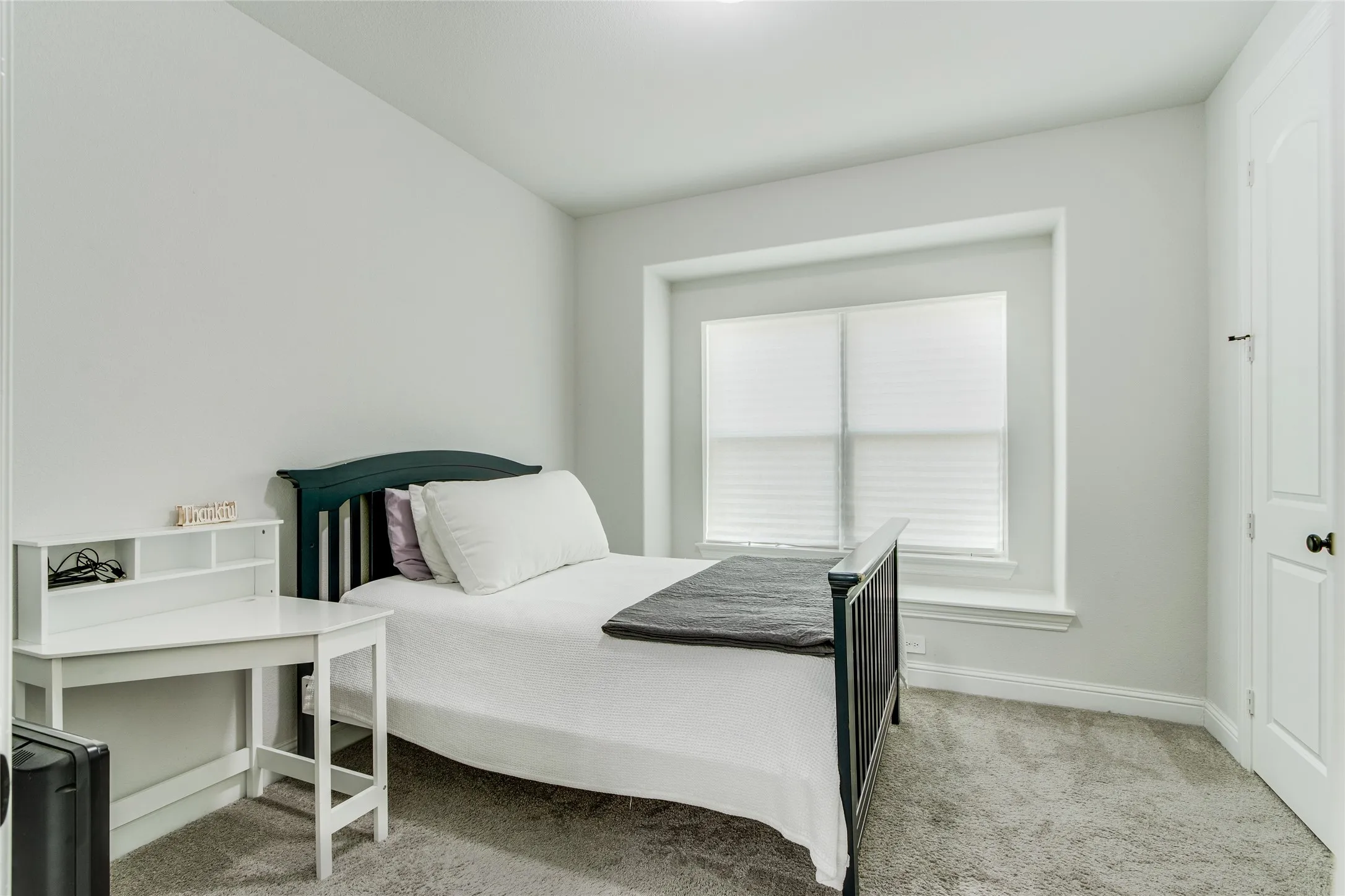 Recessed window with white blinds, neutral wall paint, and gray carpet flooring