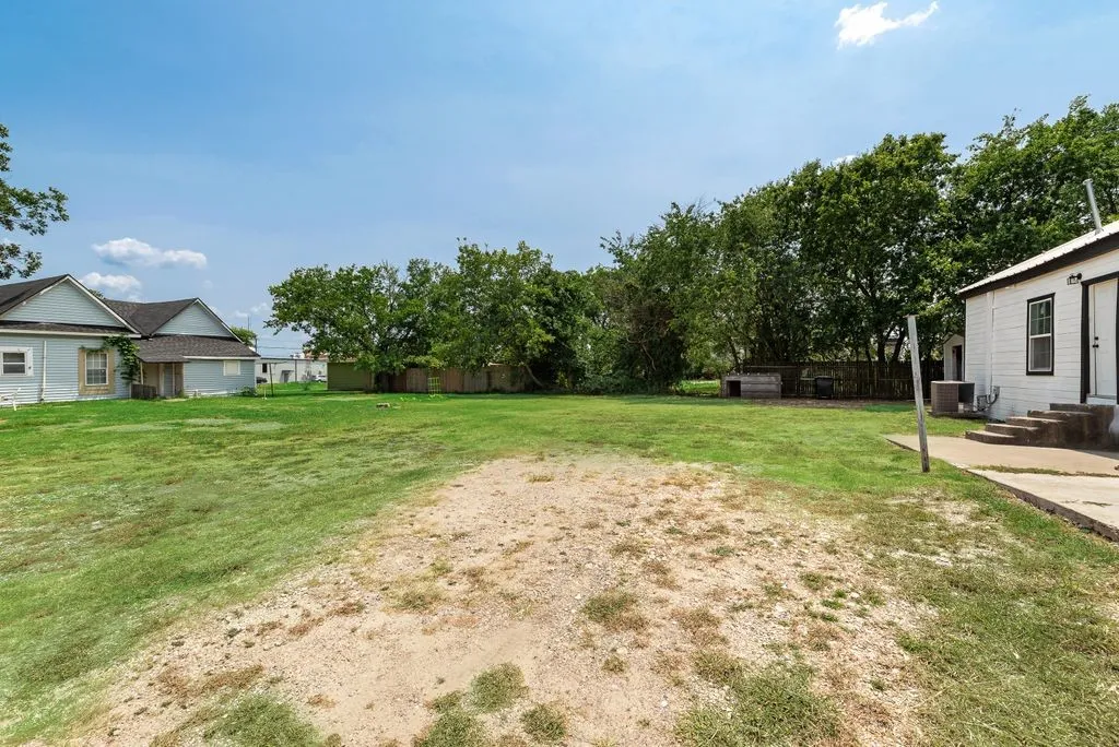 Expansive grassy yard with a concrete patio