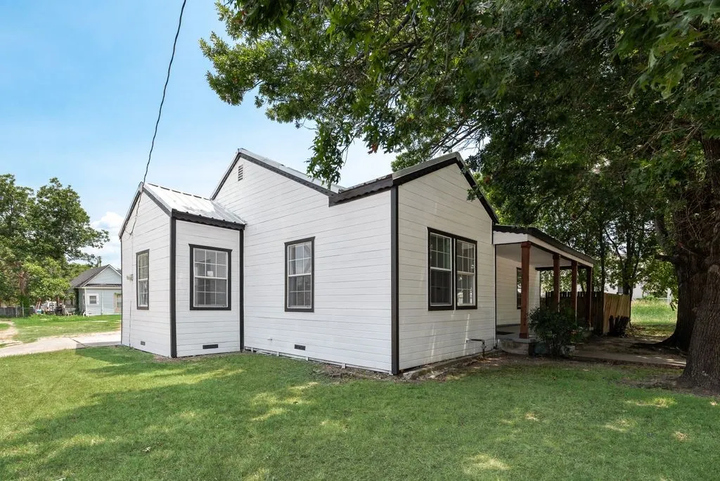 White horizontal siding exterior with black trim and a metal roof
