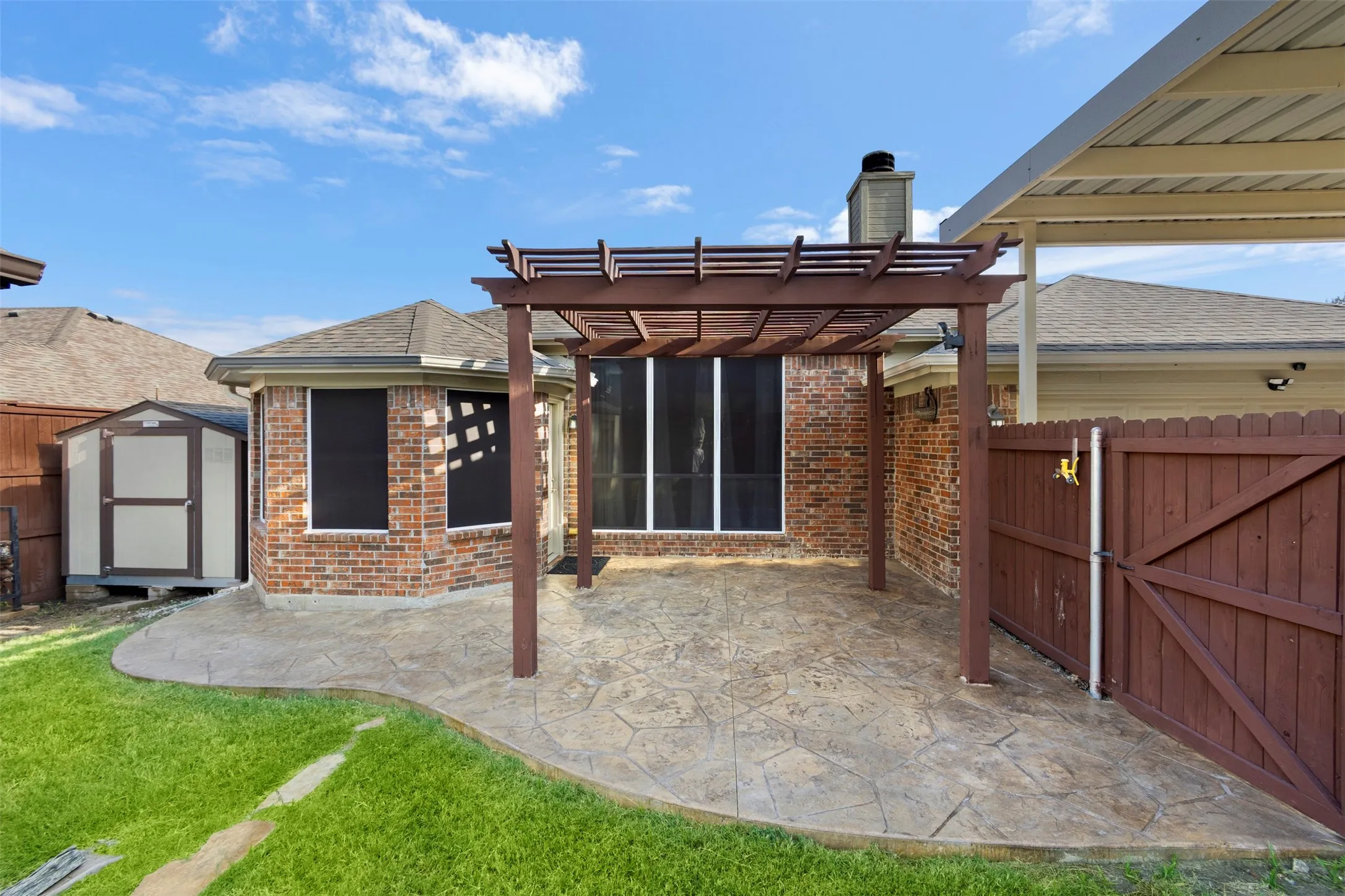 Over-sized patio with stained stamped concrete and pergola cover