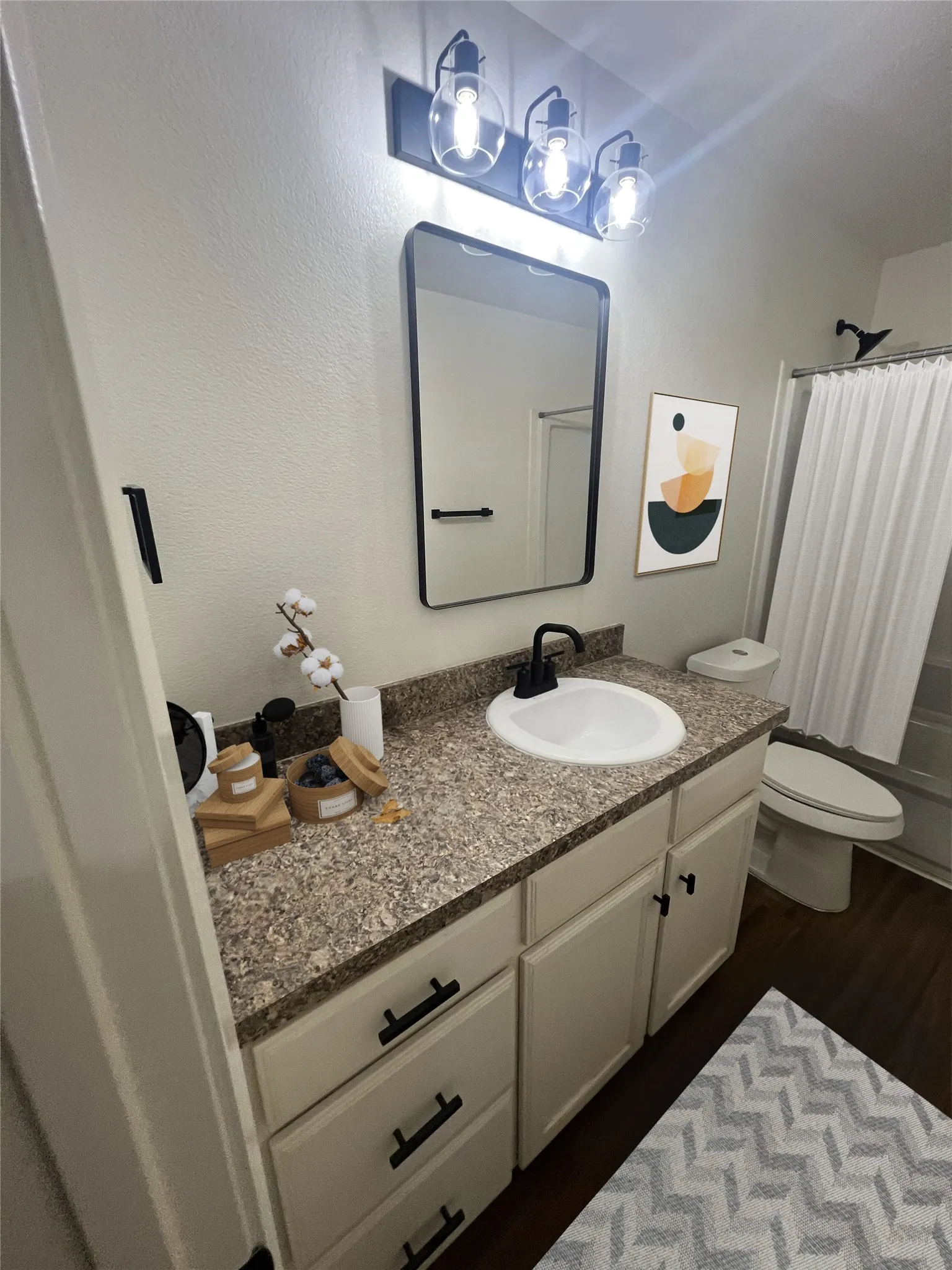 Full bath featuring vanity, wood finished floors, and shower / bath combo