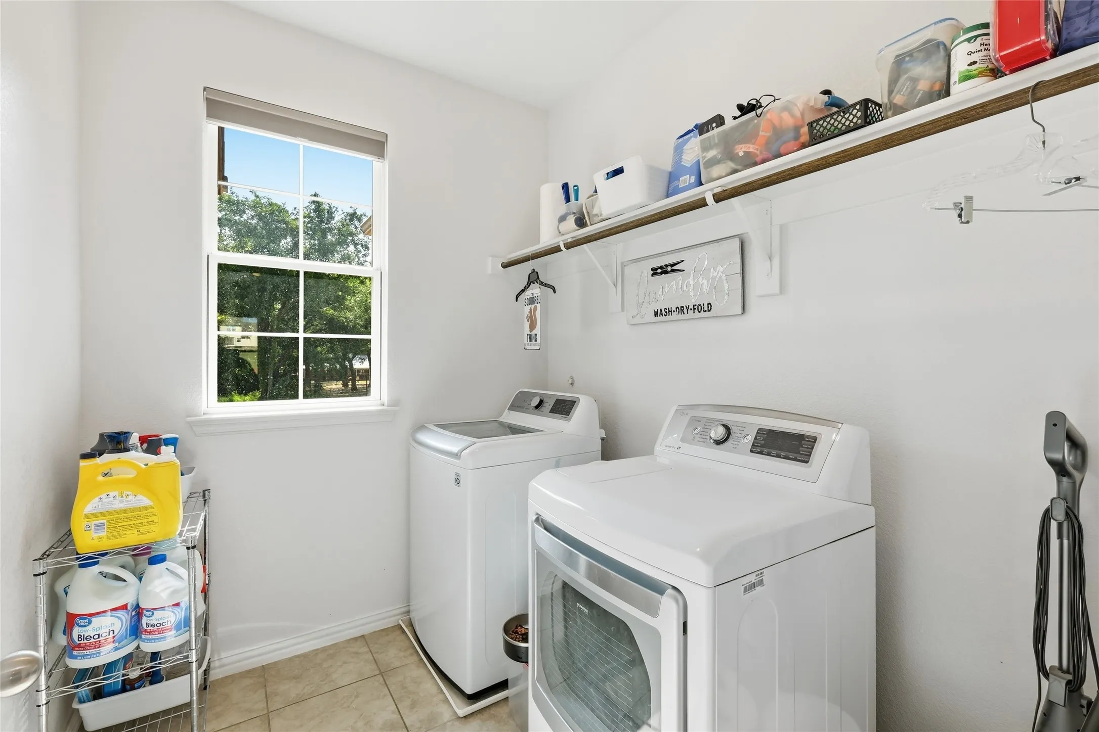 Laundry area featuring a window, tile flooring, and integrated shelving