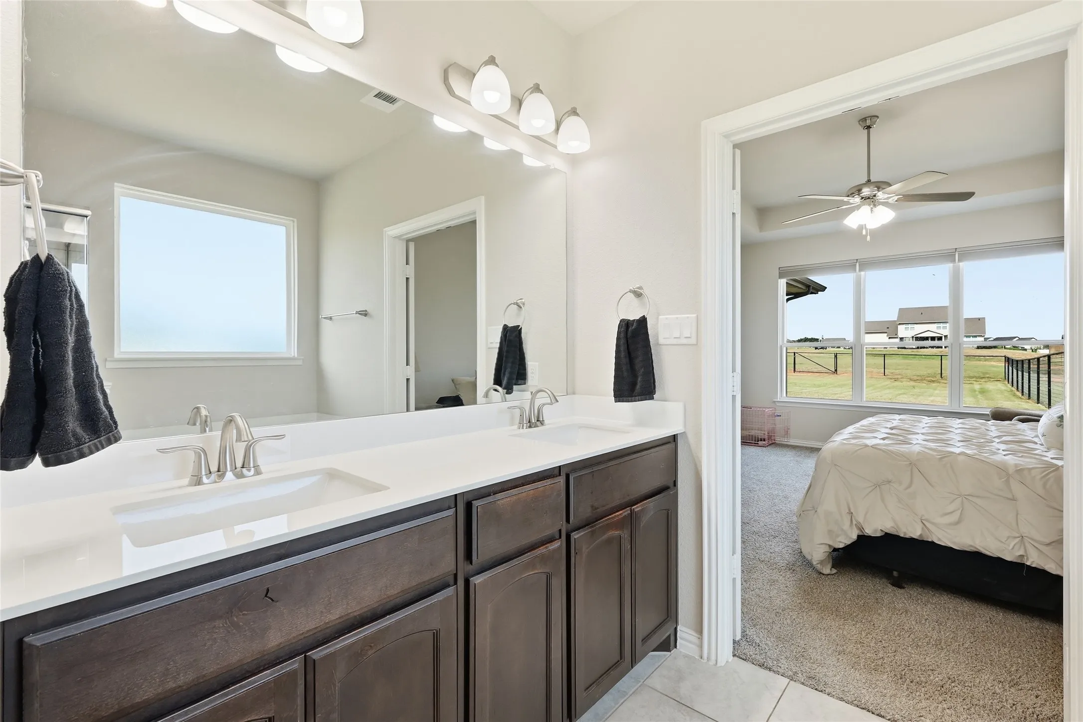 Dual vanity with undermount sinks, white countertop, and dark wood-finish cabinetry
