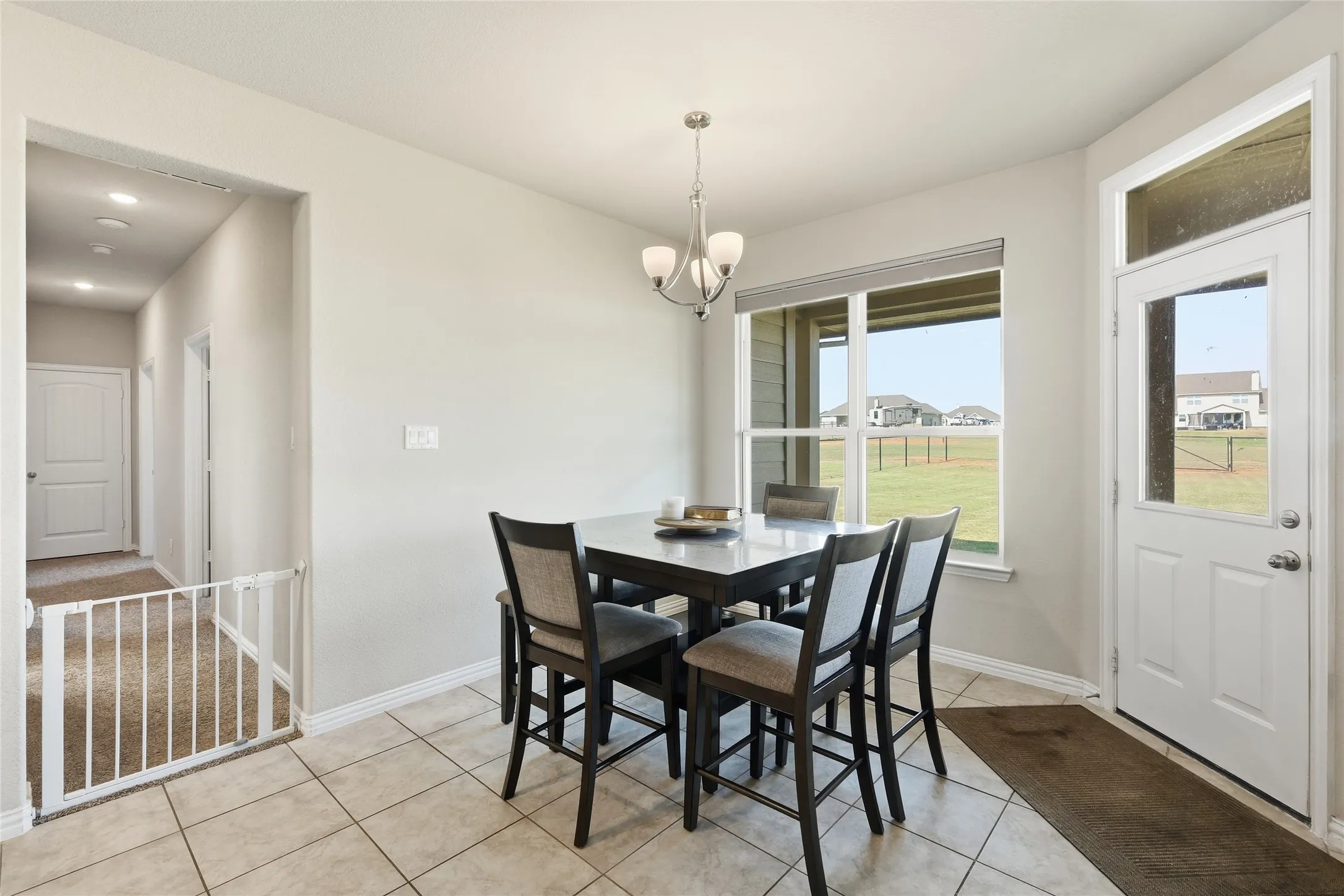 Tiled flooring, pendant lighting, large window, side door with glass panel, recessed lighting in hallway